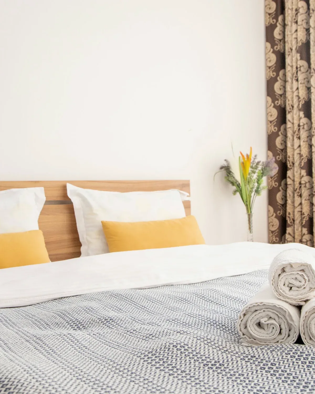 Dormitorio preparado con cama ordenada y toallas para un servicio de aseo tipo hotel
