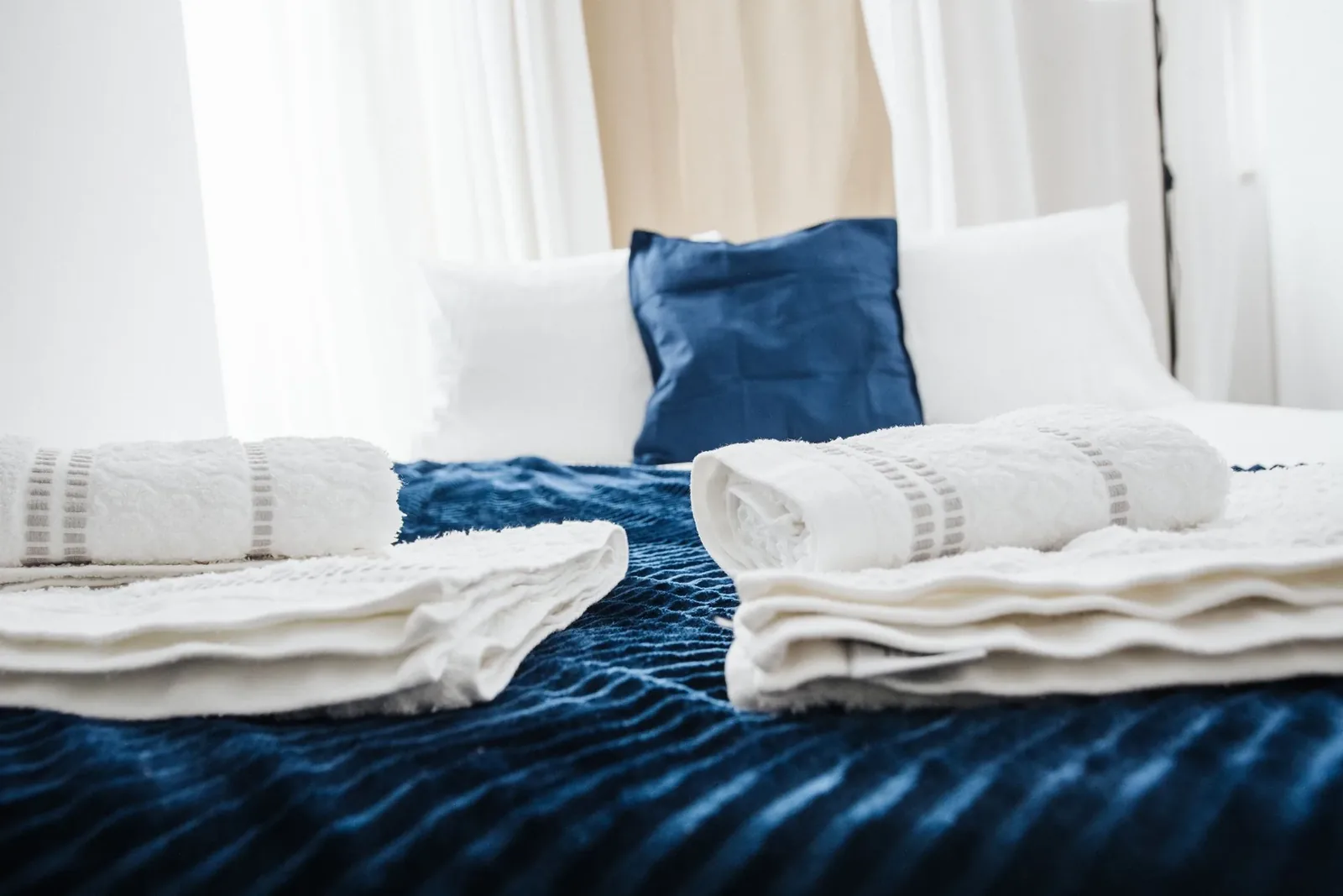 Dormitorio luminoso con cama preparada y toallas ordenadas