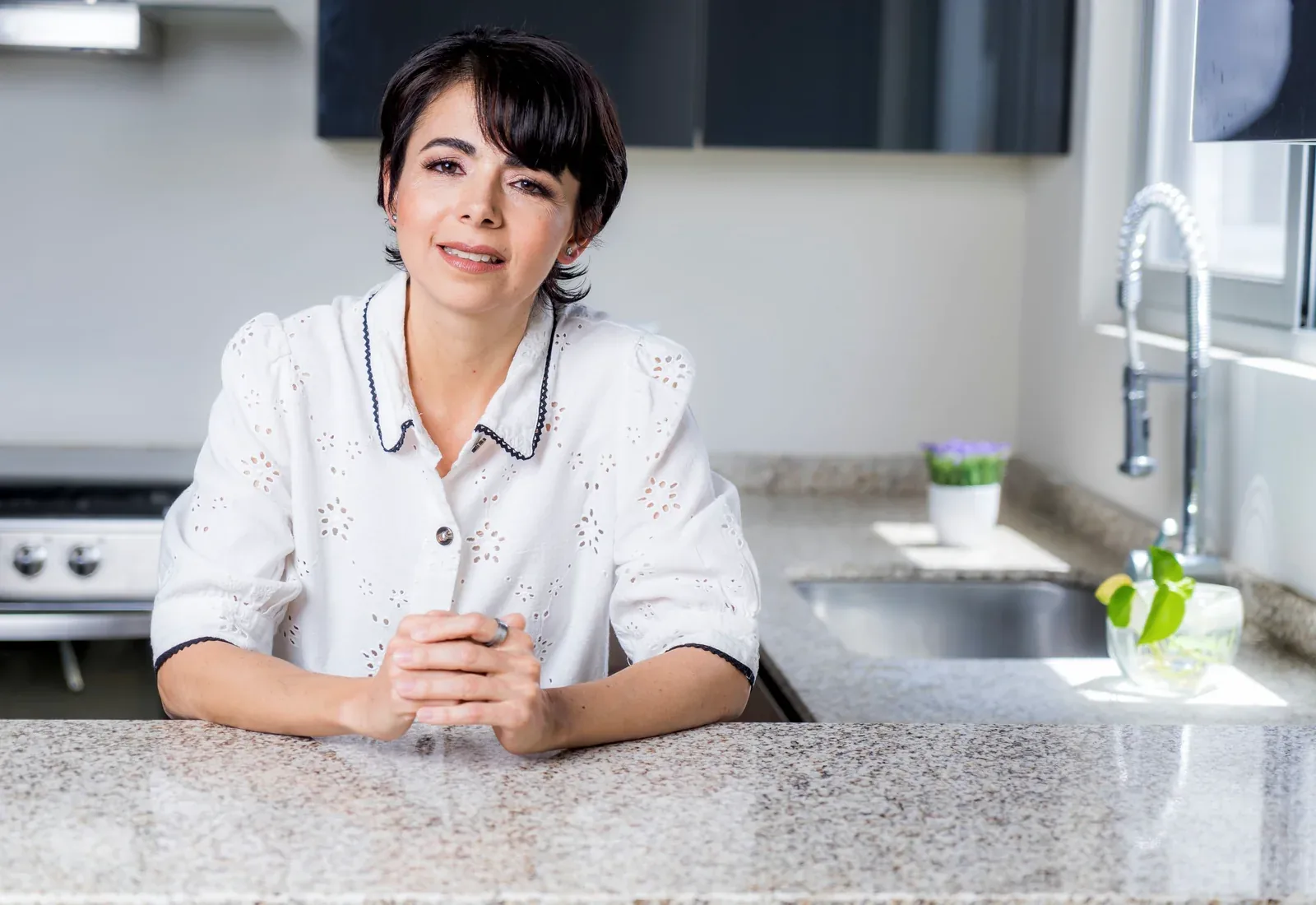 Mujer hispana en una cocina luminosa, limpia y ordenada